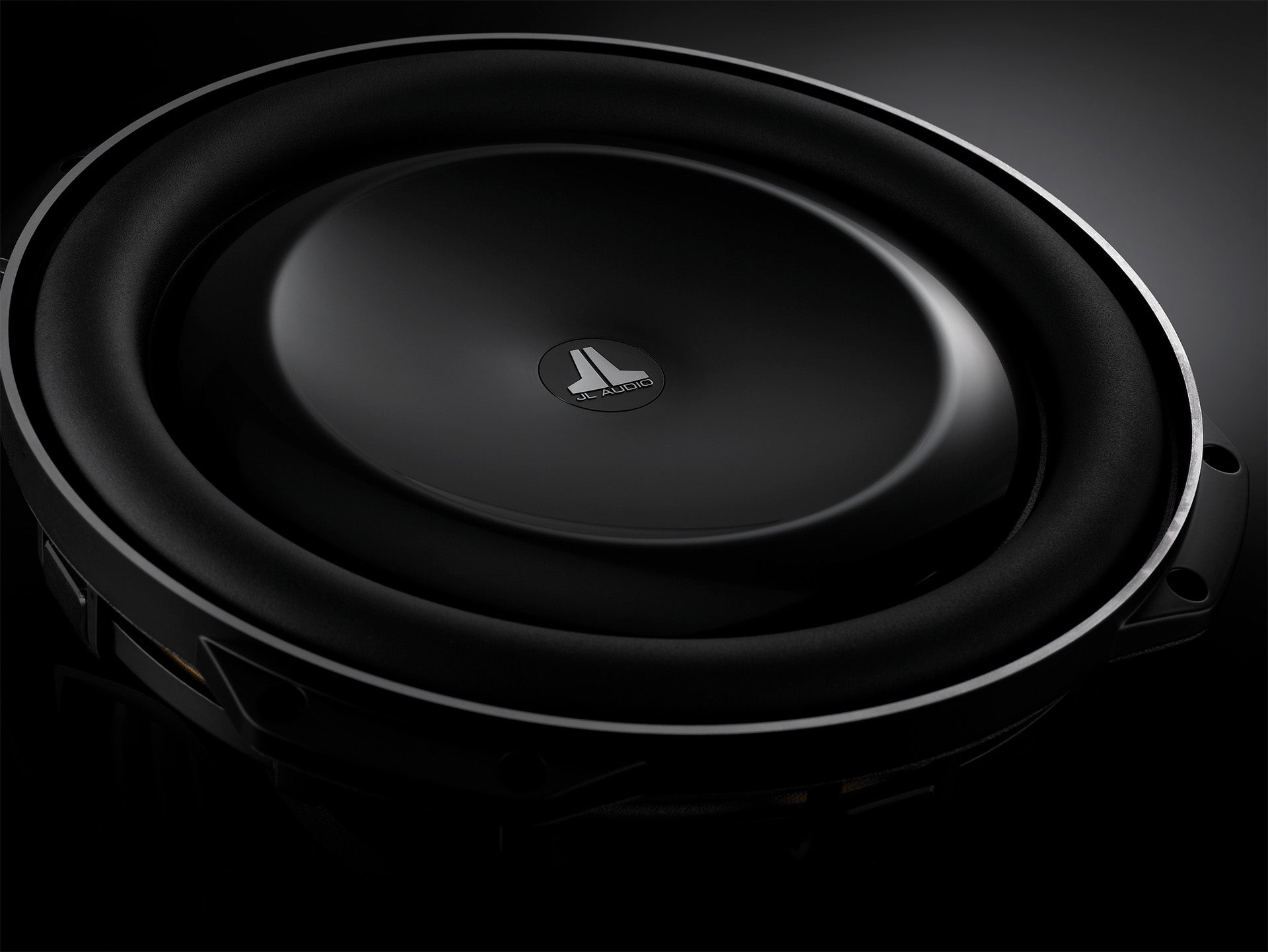 Close-up view of TW5v2 driver used in JL Audio IWS 13 subwoofer units in dark sleek setting.