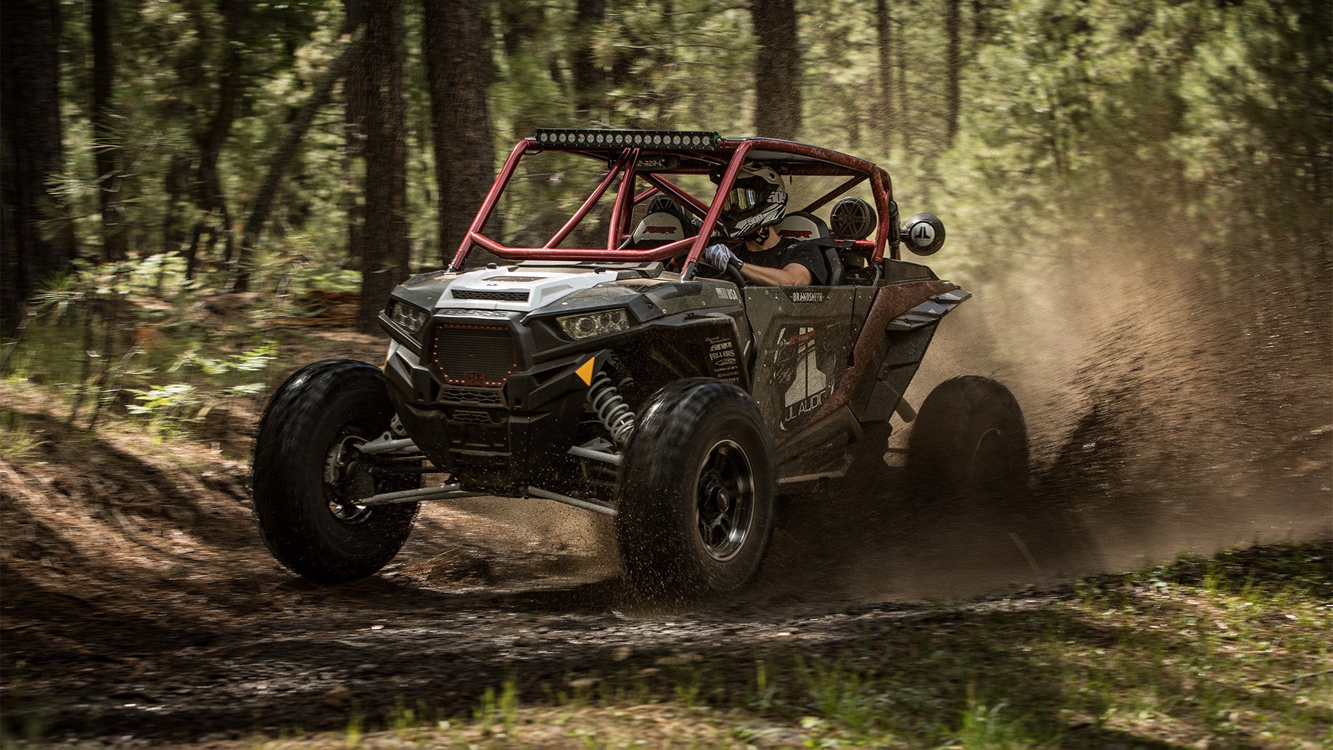 A powersports vehicle with Stealthbox going through rugged terrain.