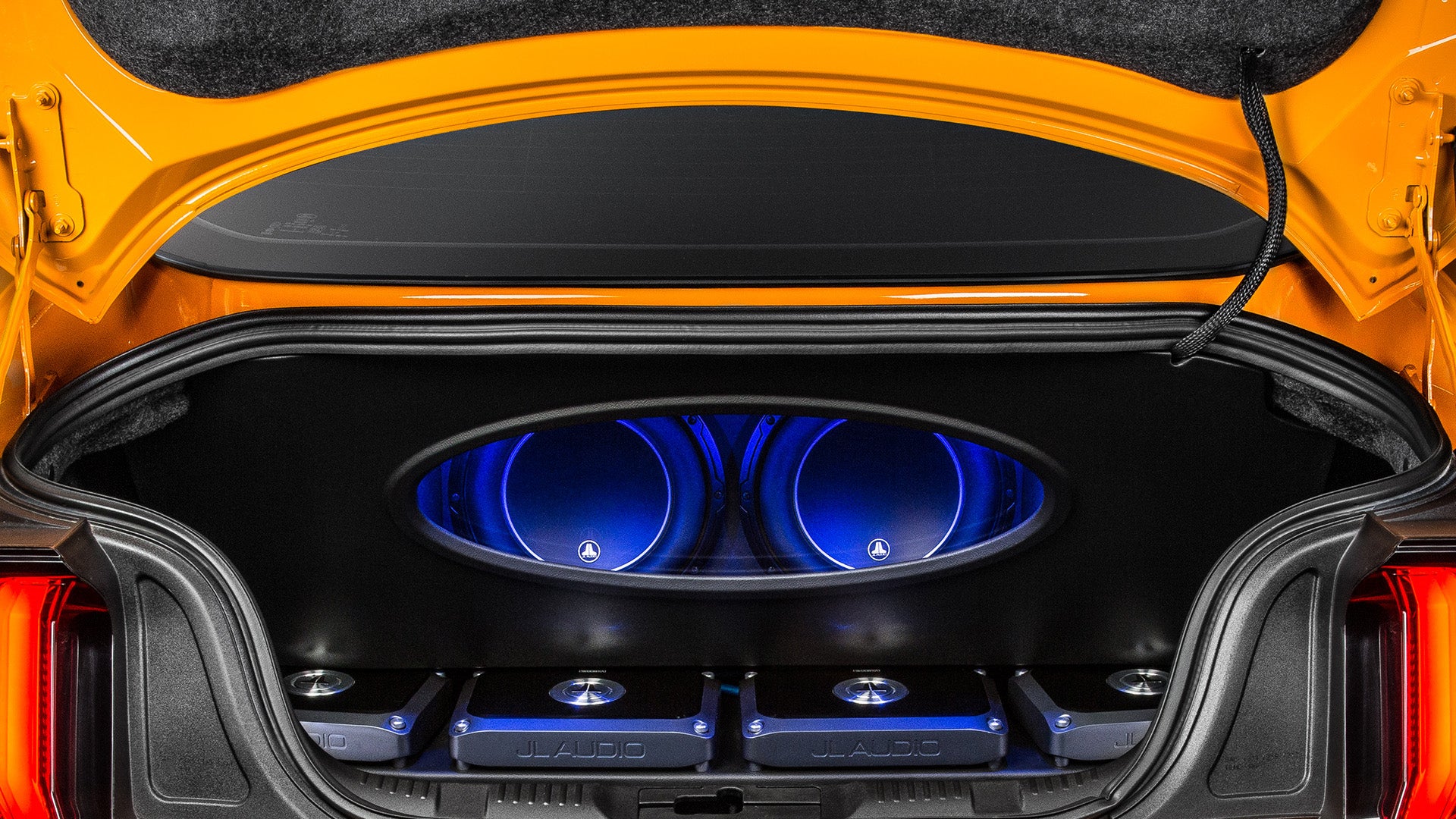 A trunk of a Mustang car with a pair of installed W6v3 car audio subwoofer units.