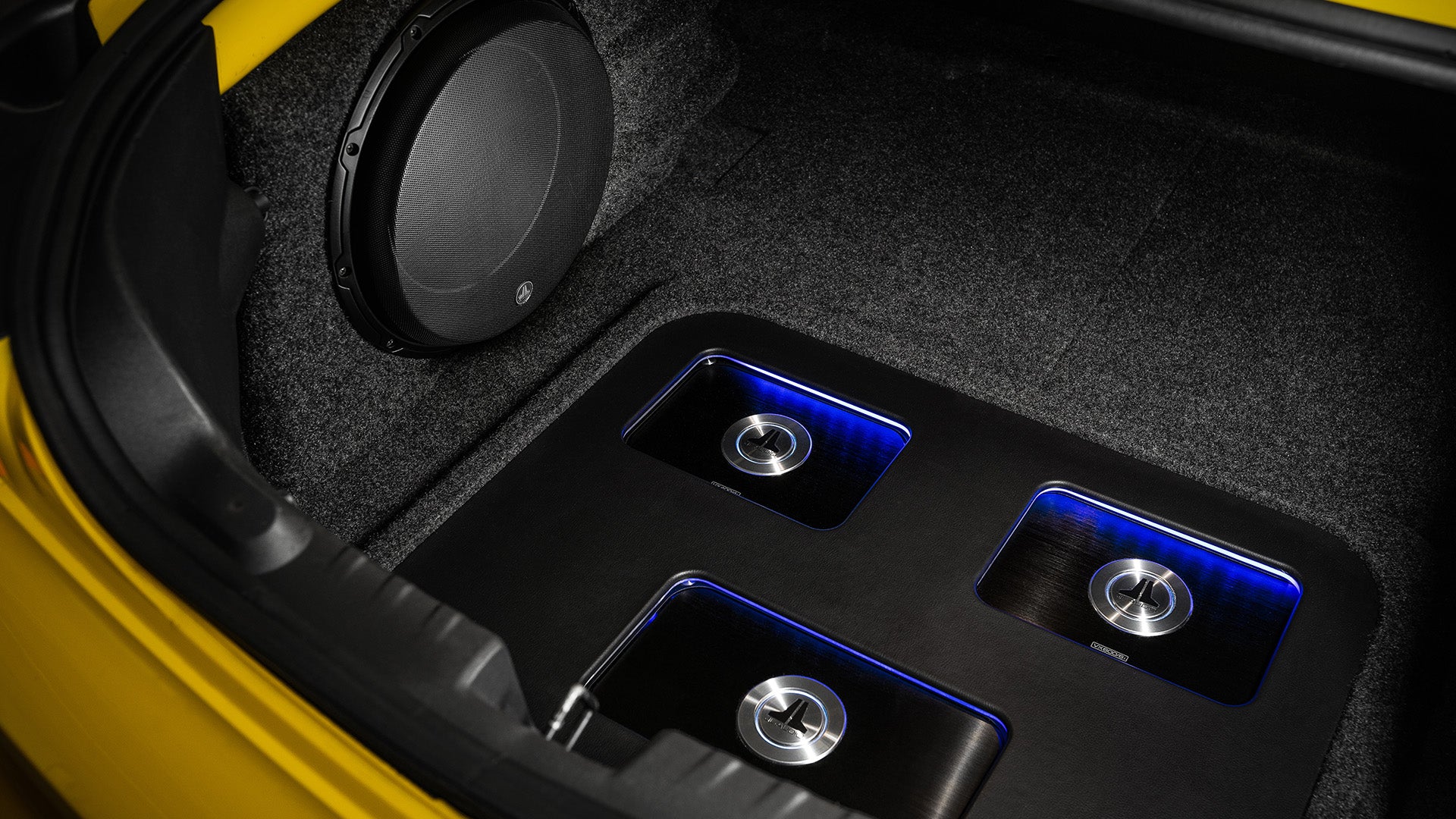 An open trunk with 3 JL Audio Amplifiers. 