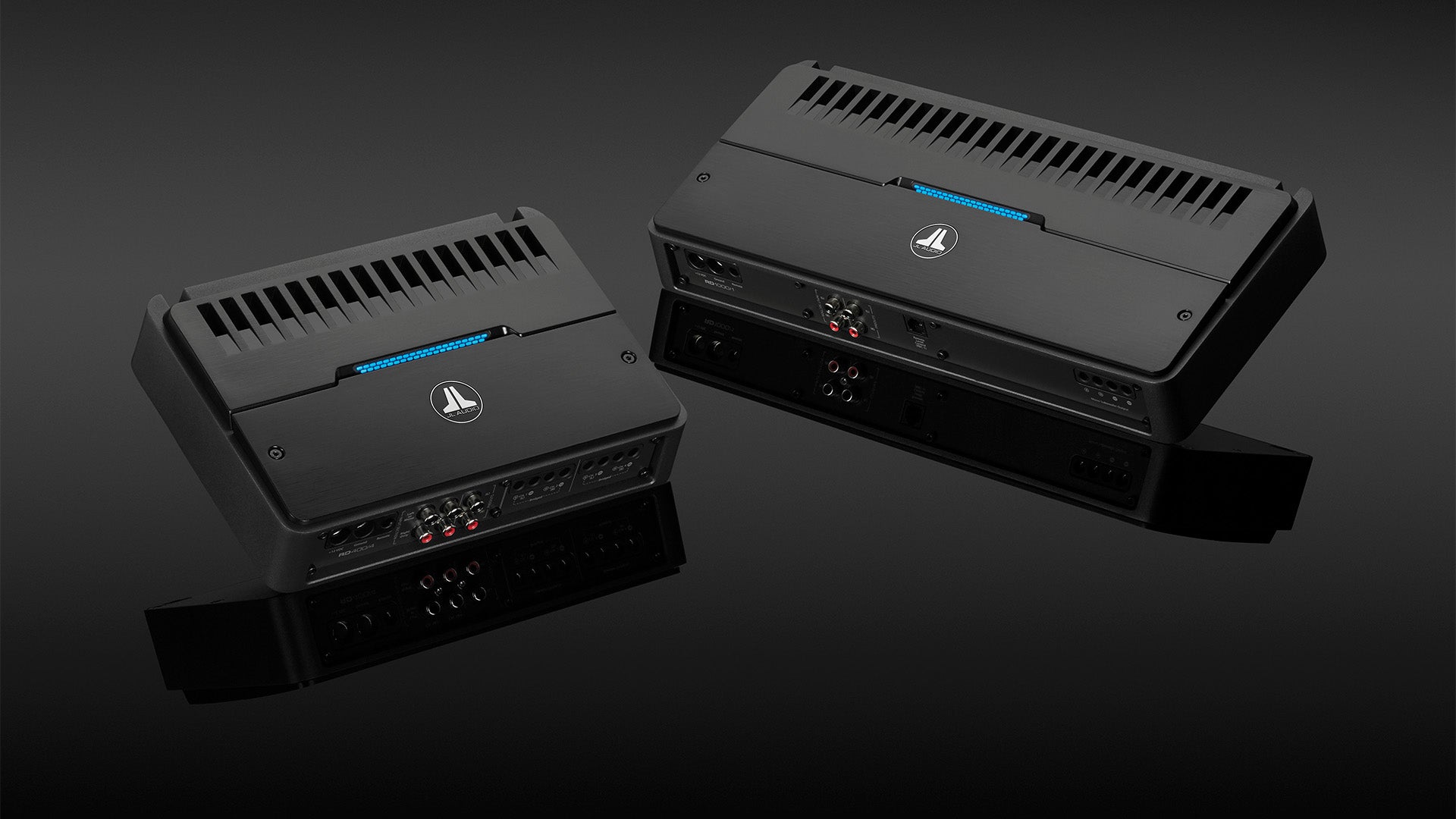 A pair of RD amplifiers on a sleek reflective dark surface.