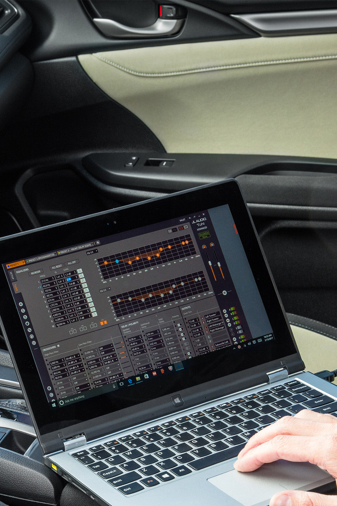 A technician using TwK 88 and a laptop to tune a car audio.