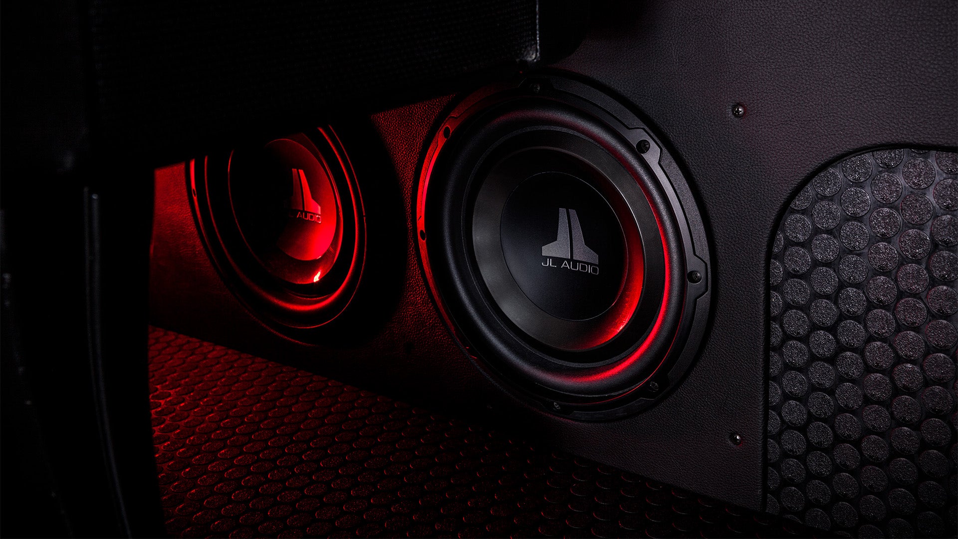 A pair of W1v3 subwoofer units in a truck with red LED lighting.