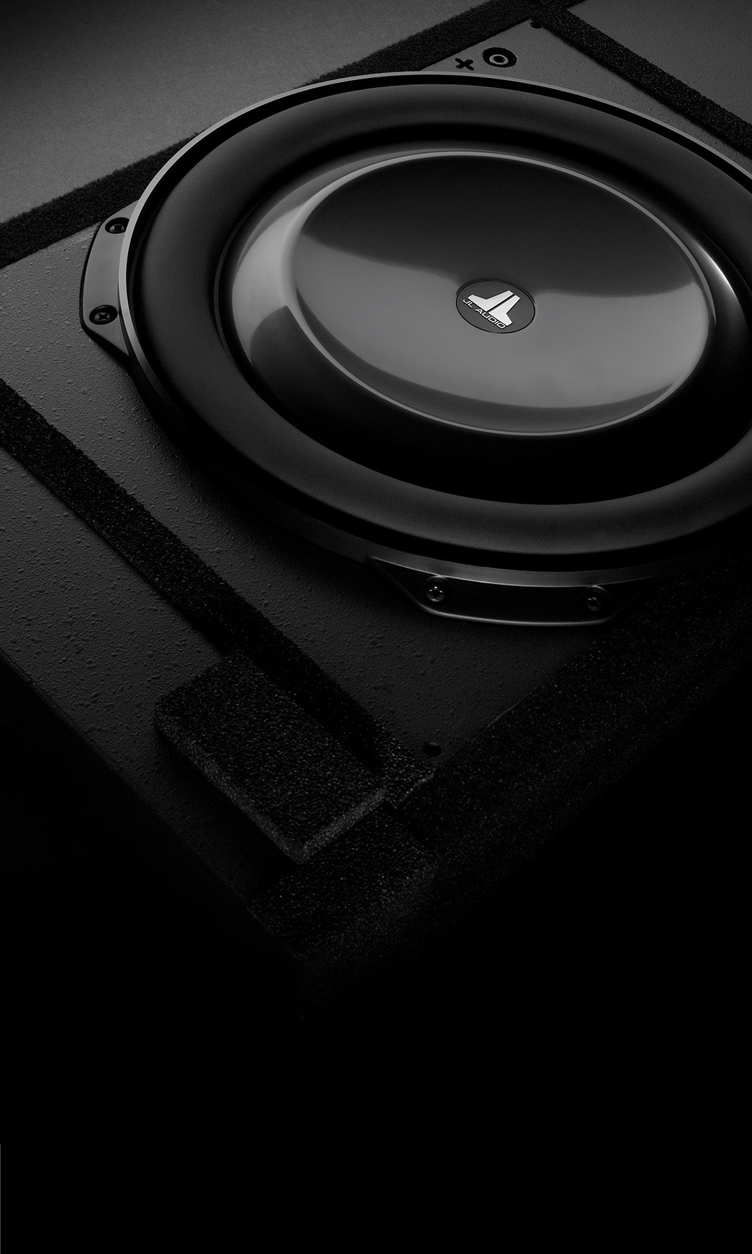 Close-up view of TW5v2 driver used in JL Audio IWS 13 subwoofer units in dark sleek setting.