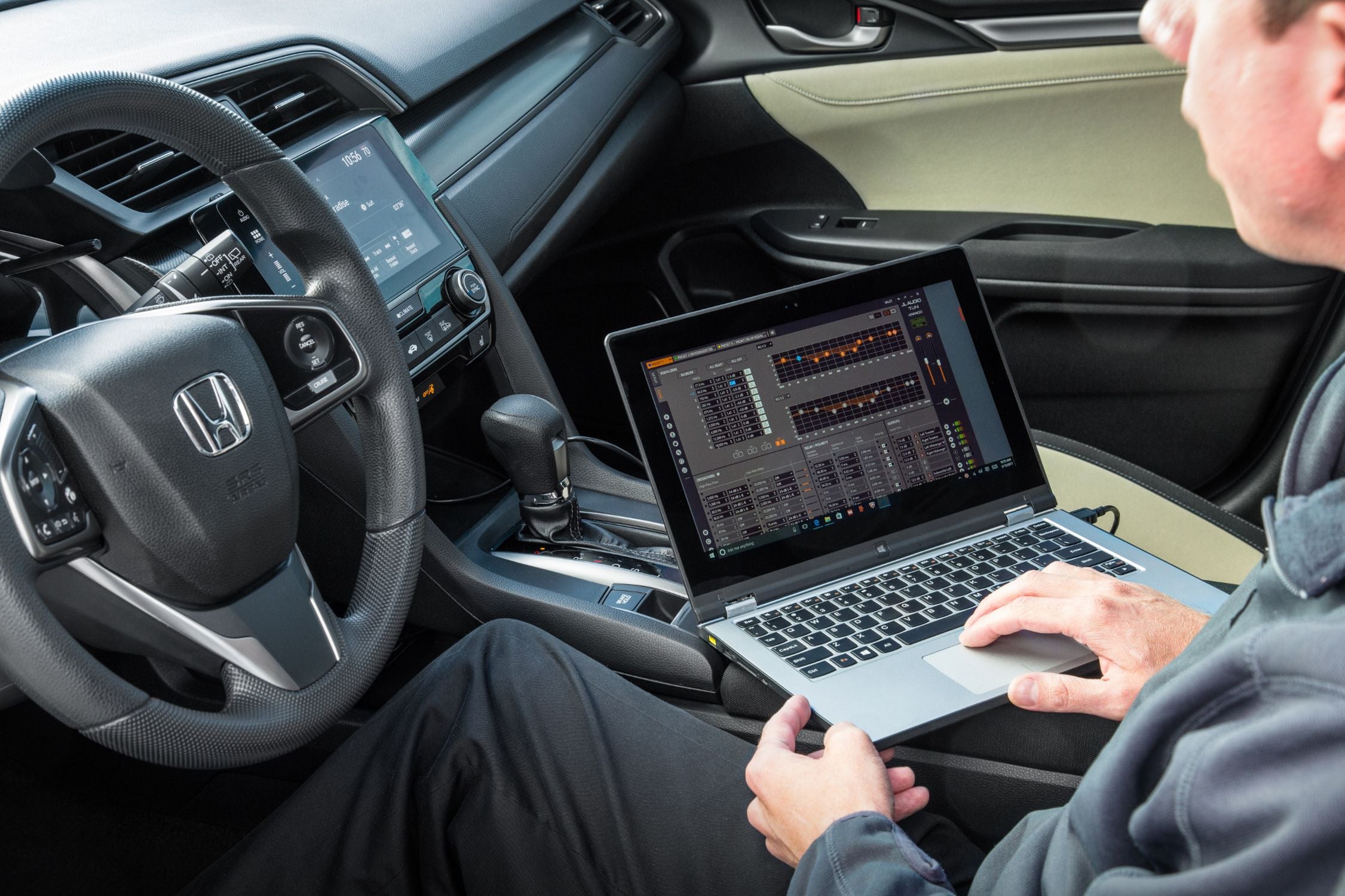 Hand on a Laptop Setting EQ with TüN Software in a Honda
